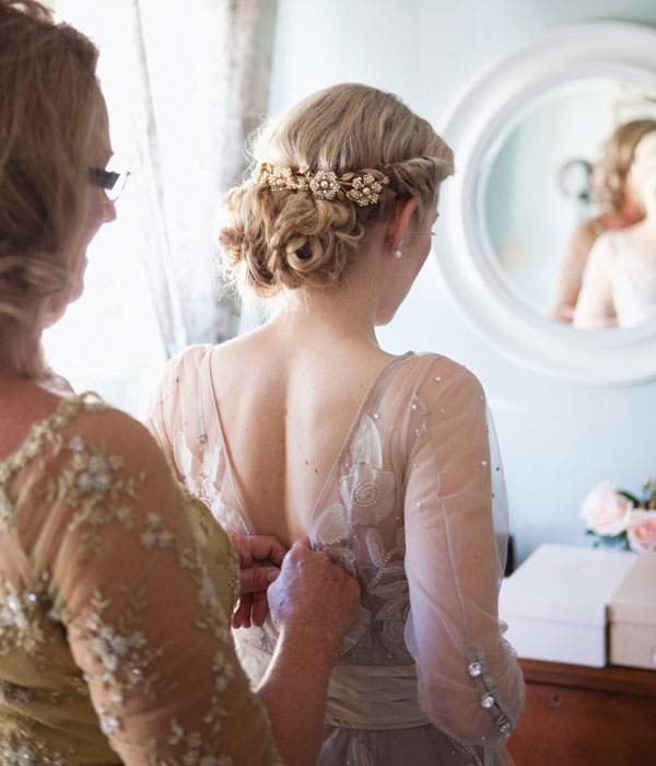 bride getting dresses with romantic wedding hairstyle