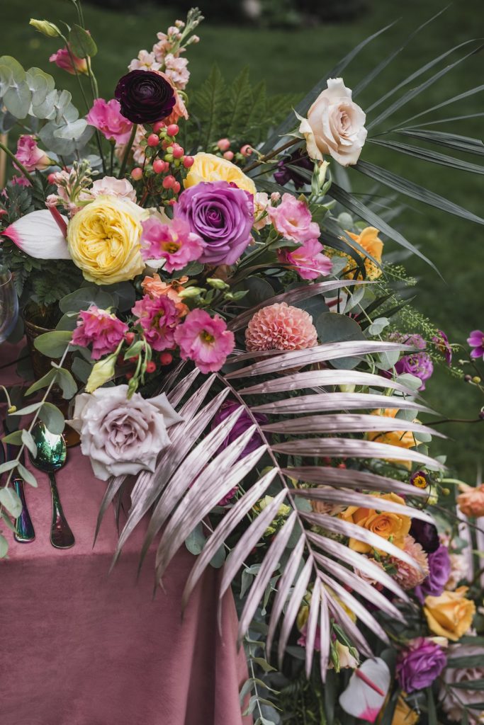 large flower installation with bold contrasting flower colours and oversized fern leafs