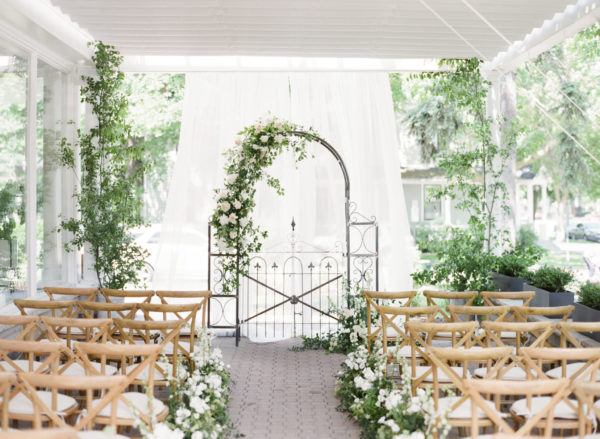 beautiful garden wedding decor with greenery and wooden chairs at Niagara On The Lake