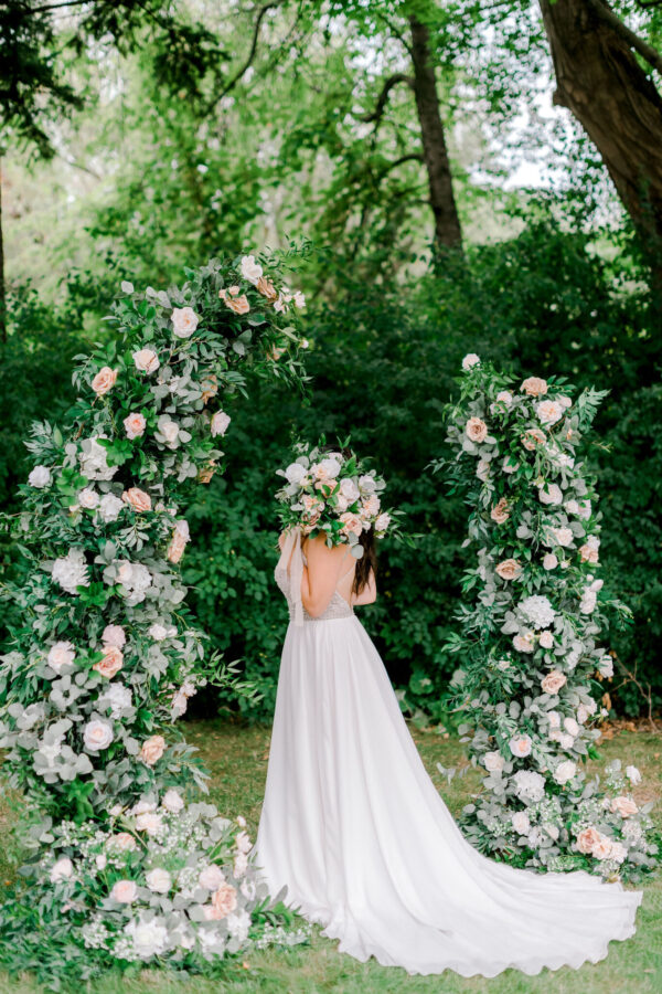 bride at the wedding flower arch