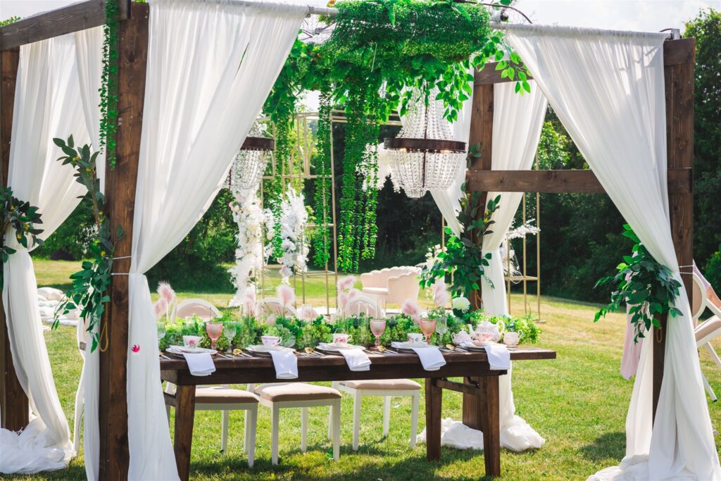 Extravagant outdoor wedding under gazebo with romantic drapery