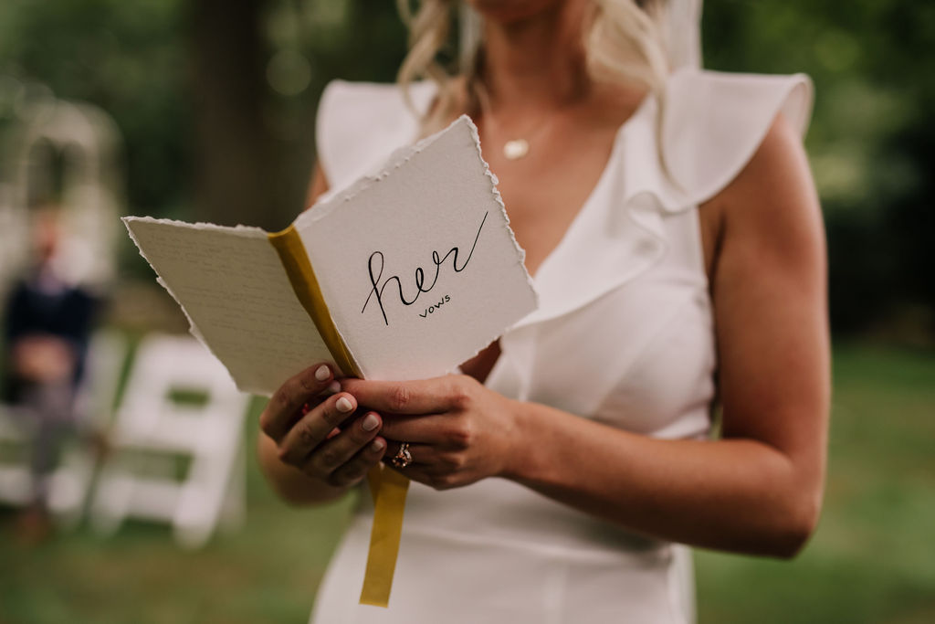 bride reading her wedding vows from a hers vow book