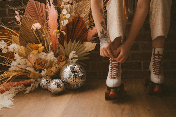 themes for bachelorette parties - Bride putting on rolling skates for her boho disco bachelorette party