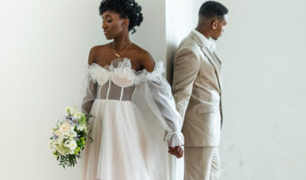 bride and groom pose for first look during wedding day timeline