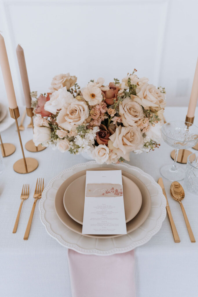 A formal table arrangement adorned with elegant gold and blush flowers