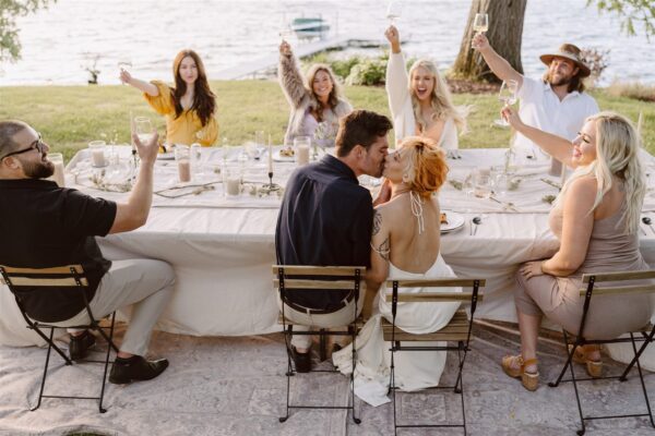 bride and groom kissing at reception table during elopement