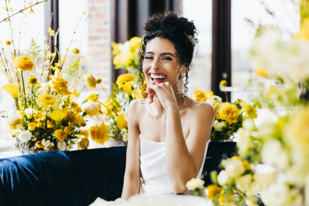 bride smiling for portrait with bold yellow flowers at unconventional wedding