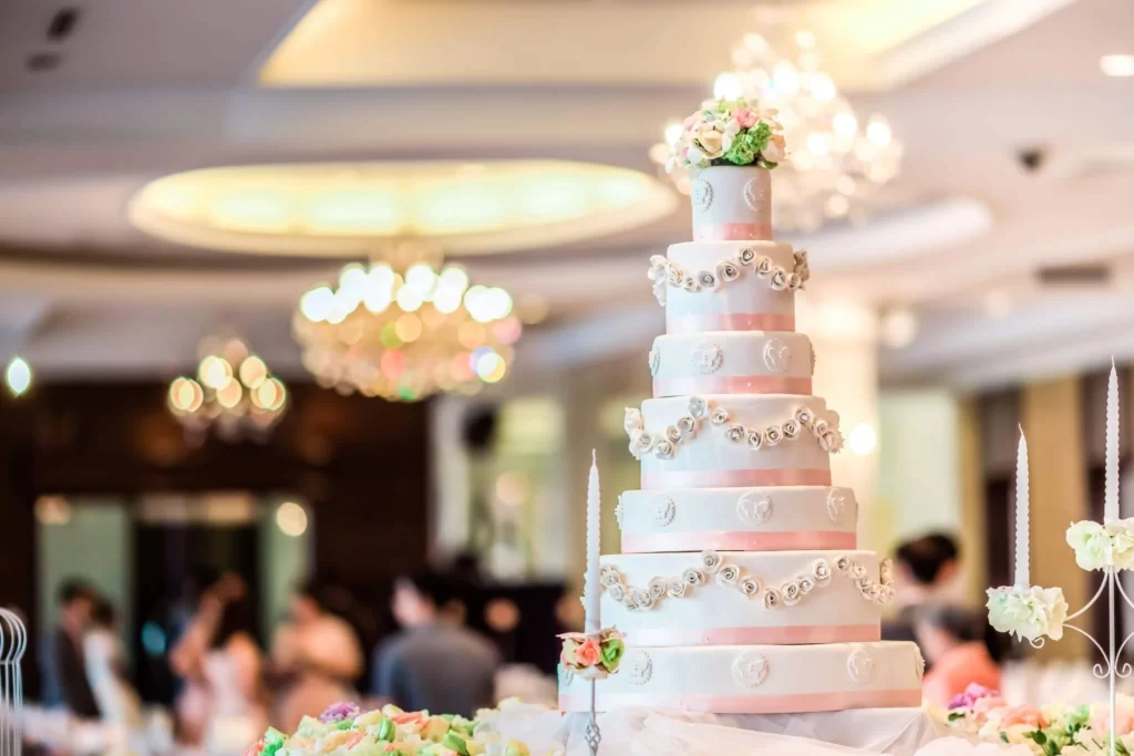 pink and white tall multi tier wedding cake in reception room