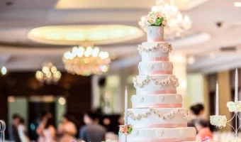 pink and white tall multi tier wedding cake in reception room
