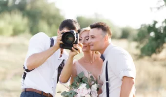 bride and groom looking at images on camera with wedding photographer