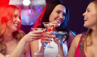 bride and bridesmaids toasting cocktails at disco bachelorette party