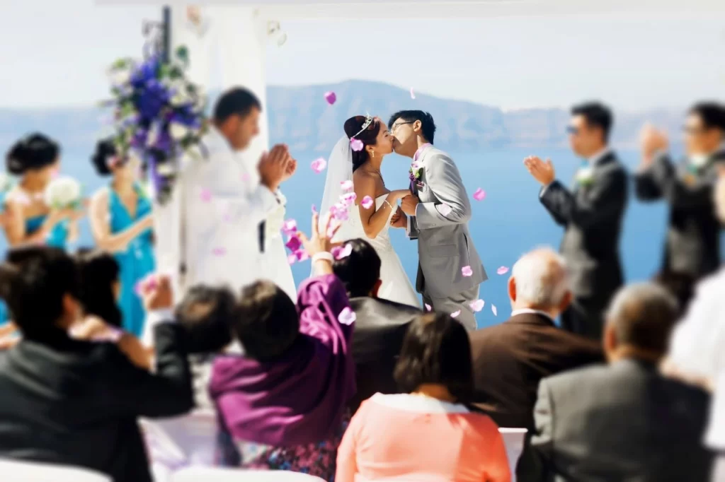 wedding guests watch as bride and groom kiss after ceremony