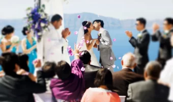 wedding guests watch as bride and groom kiss after ceremony
