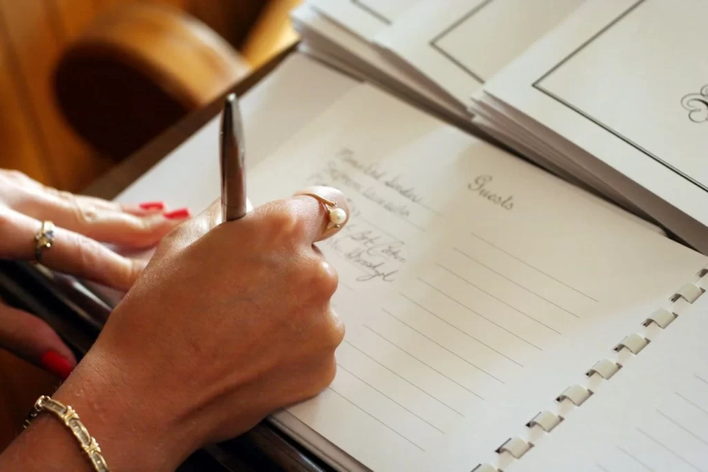 woman signing wedding guest book