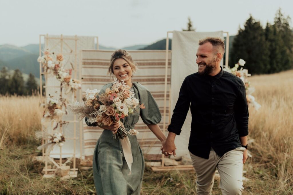 Beautiful couple holding hands after saying I do at an outdoor boho wedding. 