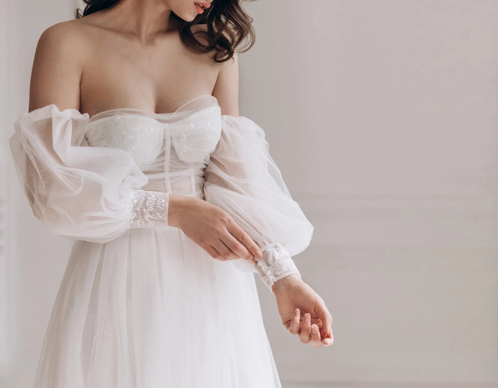 bride posing in wedding dress with detachable sleeves