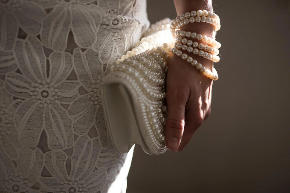 bridal look with wedding accessories: pearl handbag and pearl bracelet