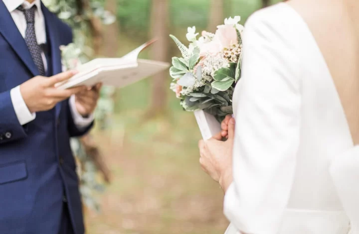 bride listening to groom recite wedding vows at outdoor boho ceremony