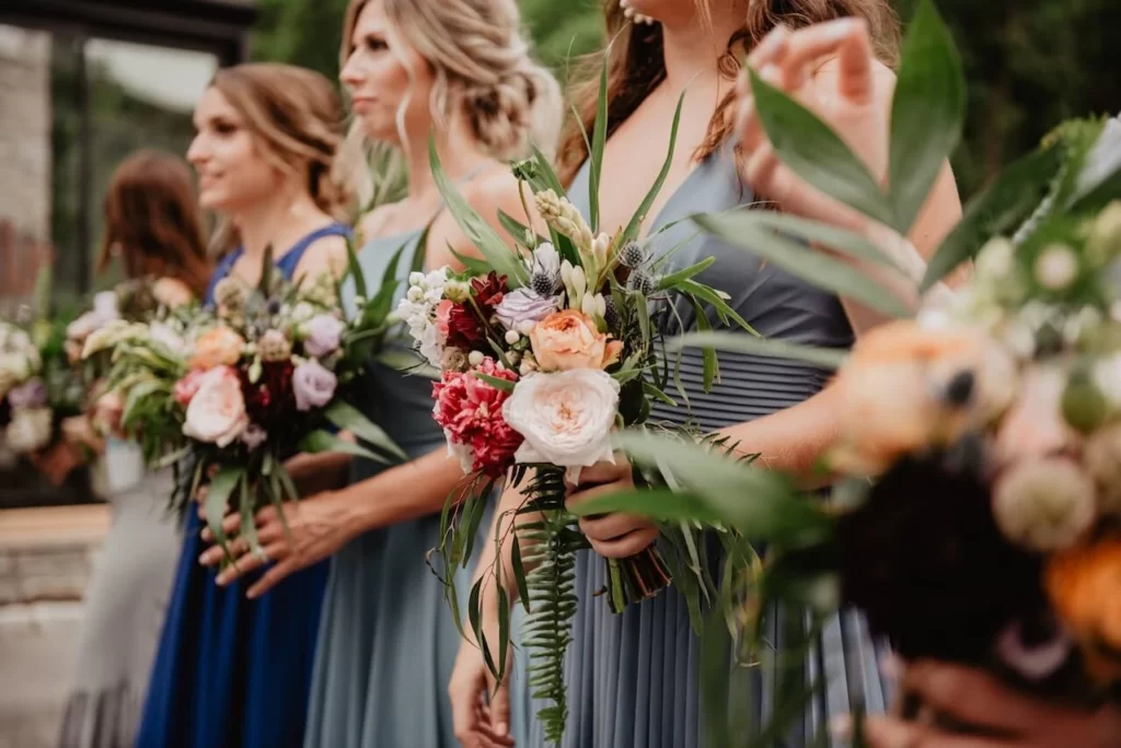 bridesmaids standing holding wedding bouquets with unique flowers