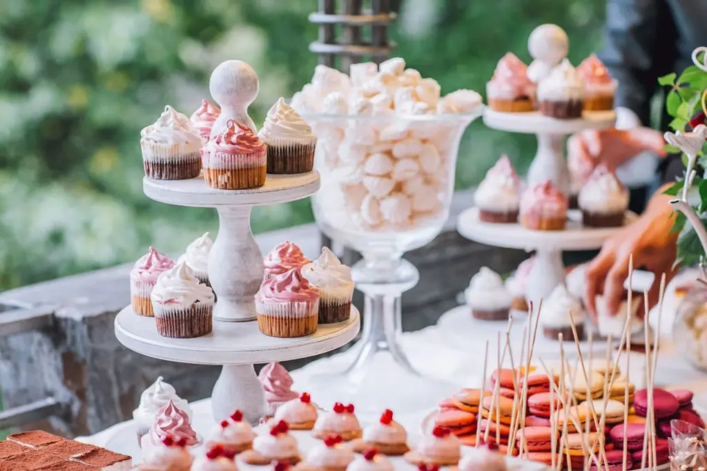 wedding dessert table filled with macaroons and cupcakes