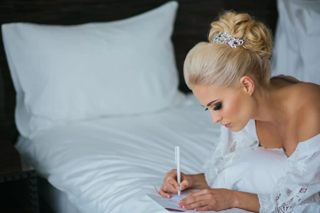 bride laying on bed writing a letter to partner
