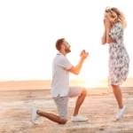 woman jumping with excitement on beach after getting newly engaged