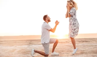 woman jumping with excitement on beach after getting newly engaged