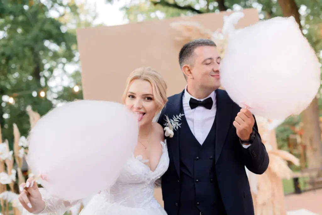 Bride and groom eating cotton candy at wedding