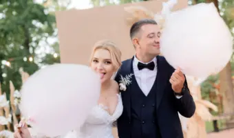 Bride and groom eating cotton candy at wedding
