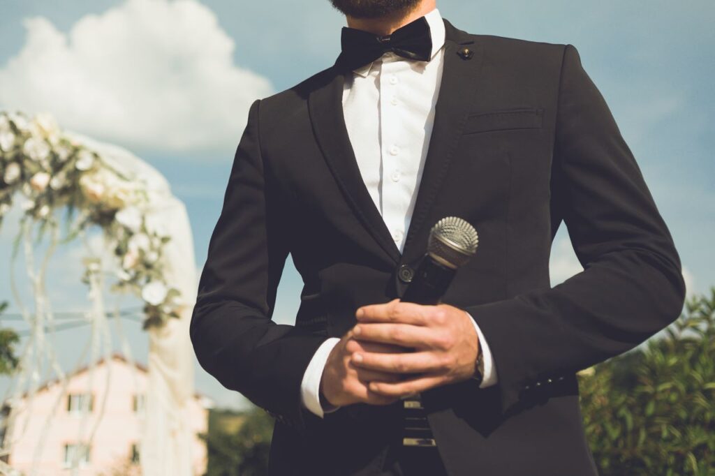 Groom standing at outdoor wedding waiting to give groom speech