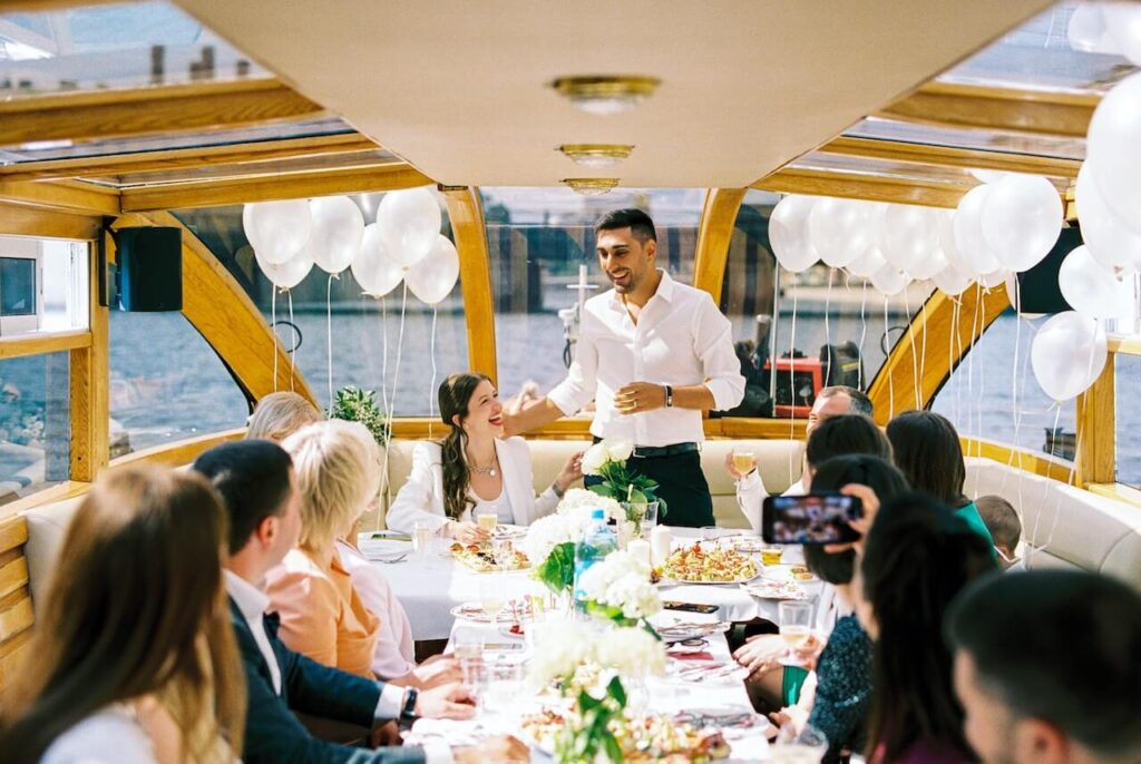 Groom standing on boat giving groom speech