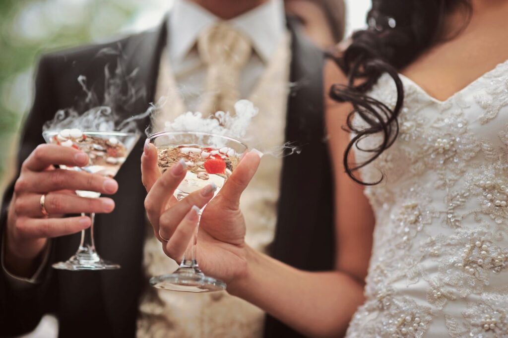 bride and groom get signature champagne drinks from wedding bar