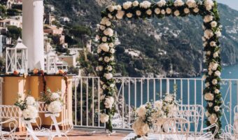 Amalfi Coast seaside wedding ceremony with beautiful arch with white flowers and greenery