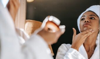 bride in bathroom applying skincare products pre-wedding spa treatment