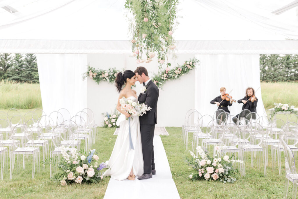 bride and groom at the altar with violinists 