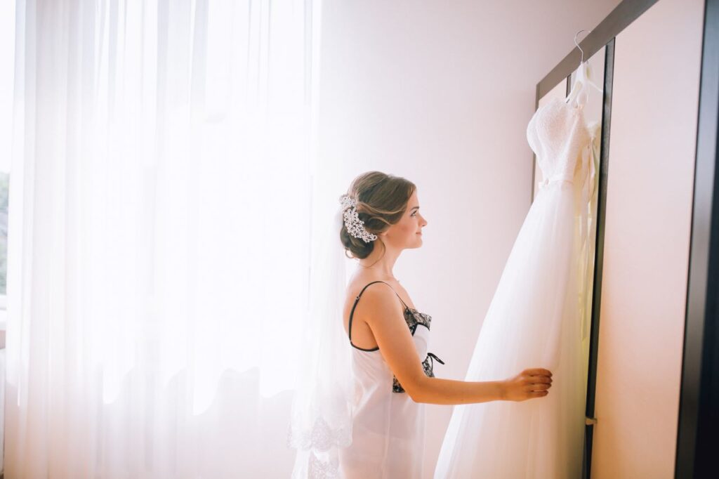 Bride getting ready for her big day, looking at her stunning wedding dress while planning her wedding 