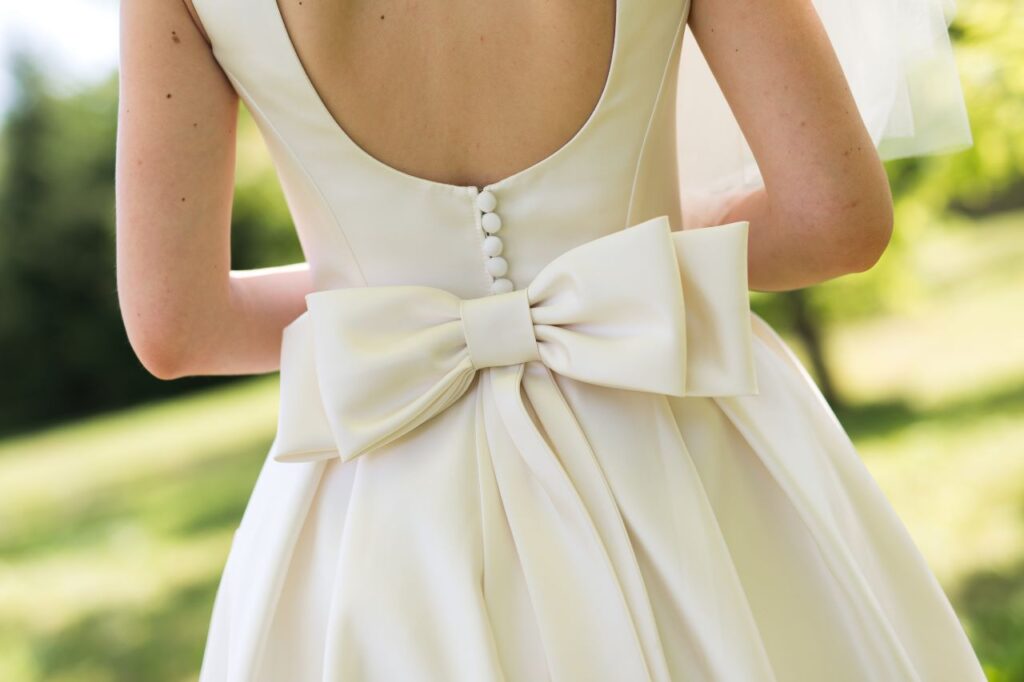 demure wedding dress with large bow on back as embellishments back view of wedding dress