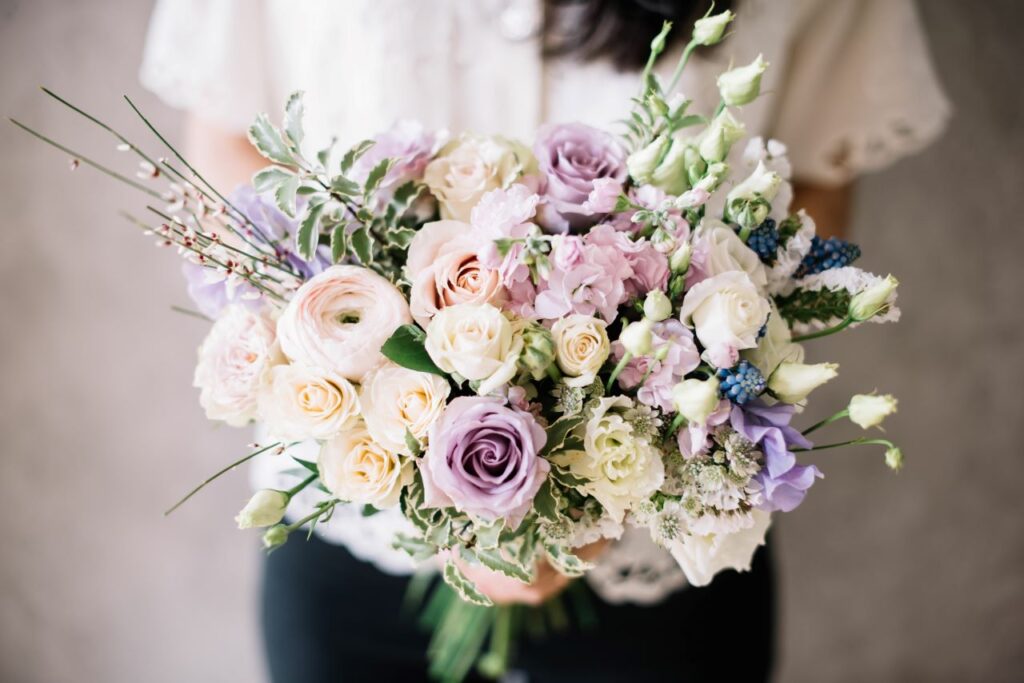 Woman holding a bouquet of white and violet Ranunculus