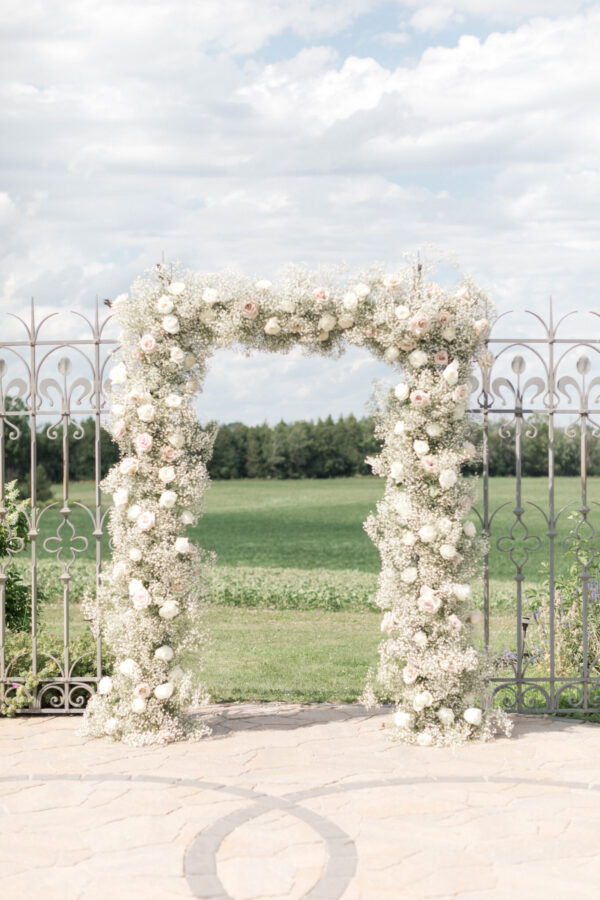 A serene landscape featuring a flower arch surrounded by lush greenery