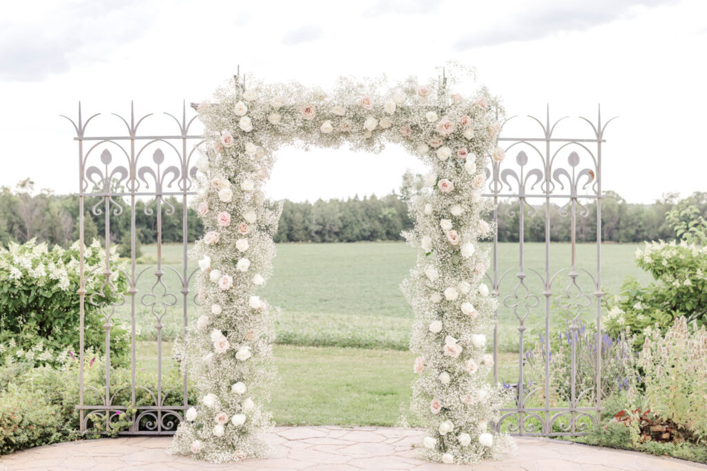 A serene landscape featuring a flower arch surrounded by lush greenery