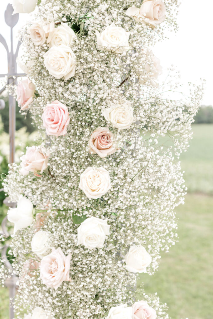 a bouquet of pink and white flowers on a metal railing