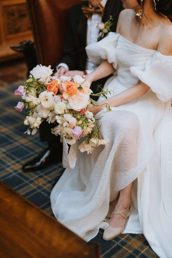 a bride and groom seated side by side in a chair