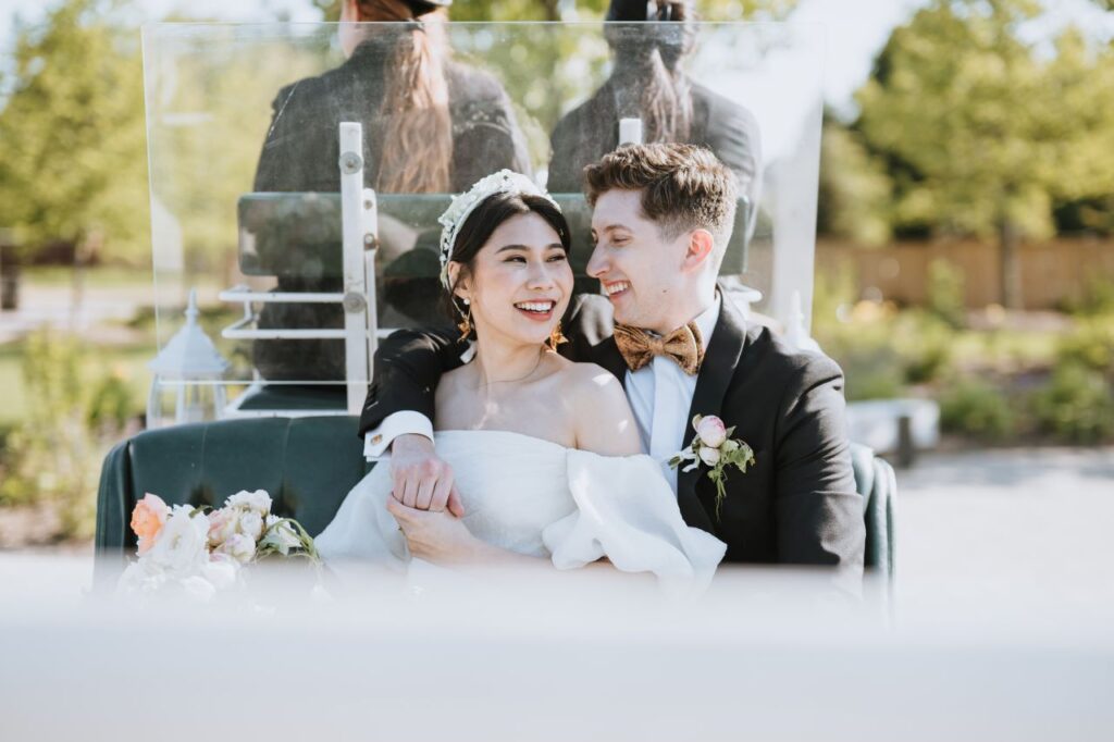 Newlyweds in a carriage, smiling and holding hands