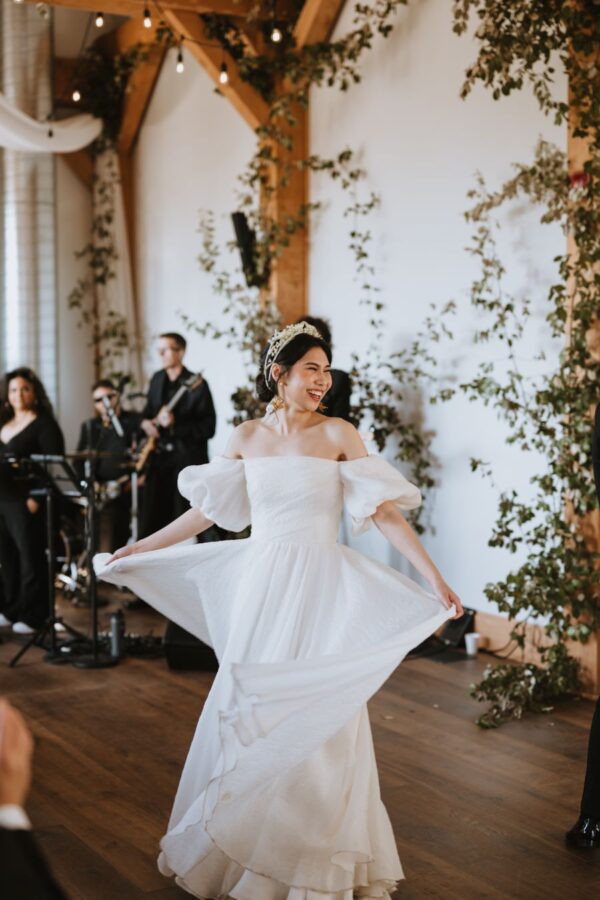 A bride and groom gracefully dance in the center of the dance floor
