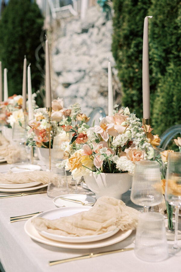 A beautifully arranged wedding reception table adorned with elegant candles and delicate flowers.