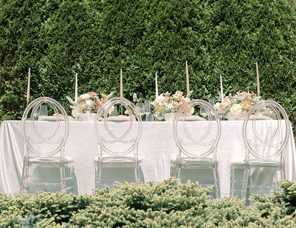 An elegant table arrangement featuring chairs and a clean white tablecloth.