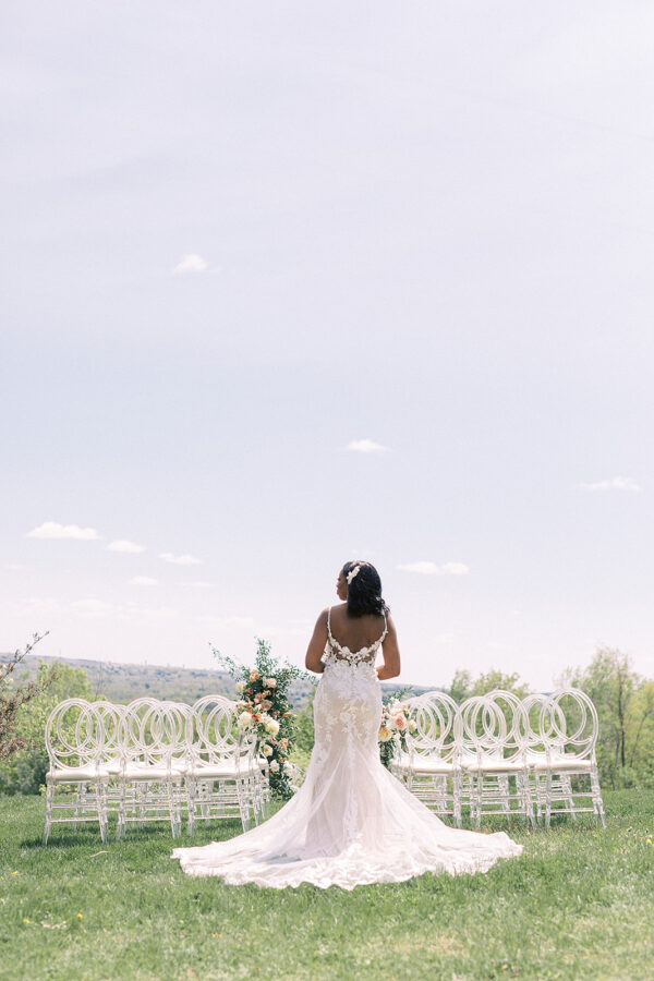 A beautiful bride stands elegantly in front of a wedding ceremony, wearing a stunning white gown