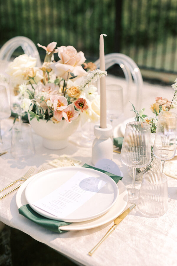 A formal table arrangement featuring elegant white and green plates, accompanied by meticulously arranged place settings.