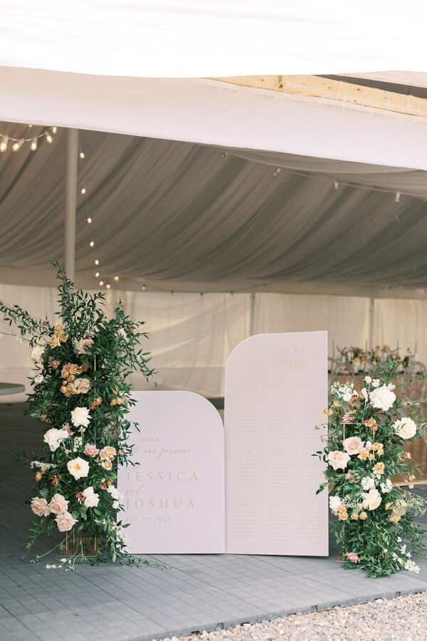 A beautifully decorated tent, prepared for a wedding ceremony, featuring exquisite floral arrangements