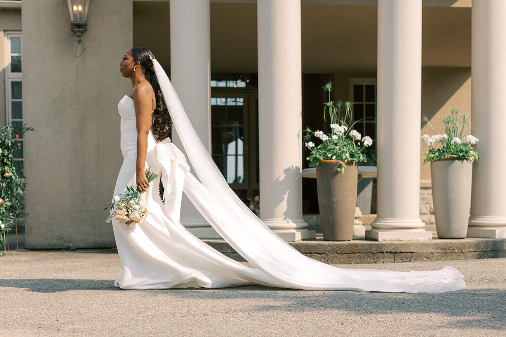 A bride elegantly poses in a long white dress